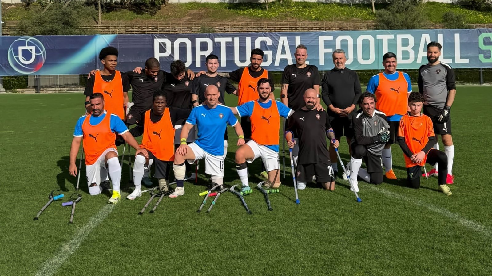 Grupo de atletas e equipa técnica de futebol para amputados em campo